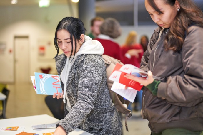 Studierende mit Informationsflyern