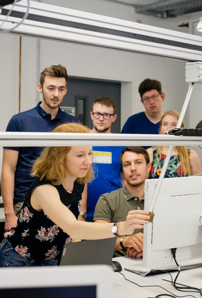 Gute Wissenschaftliche Praxis (© Hochschule München / Ulrike Myrzik ) Mehrere Promovierende schauen auf einen Laptop.