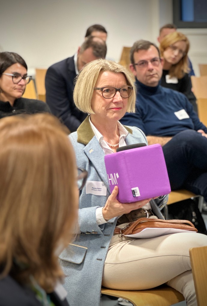 Person im Publikum stellt eine Frage