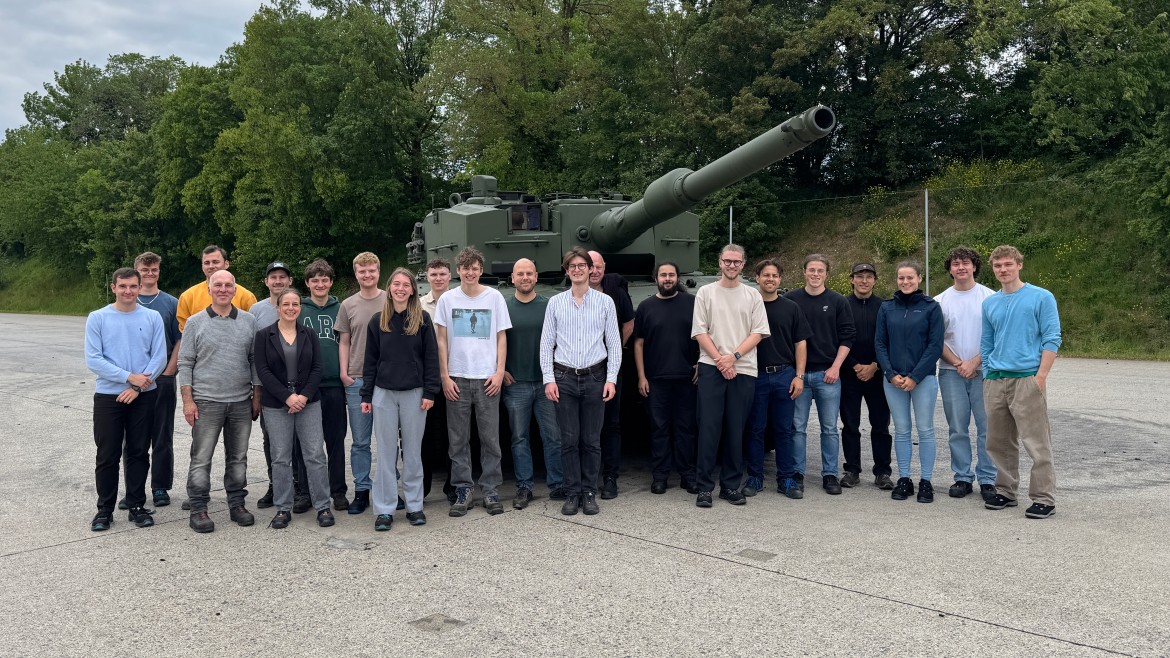 Studierende stehen vor einem Panzer