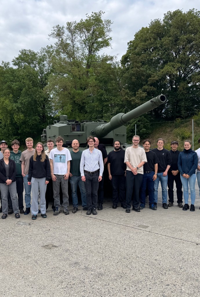 Studierende stehen vor einem Panzer