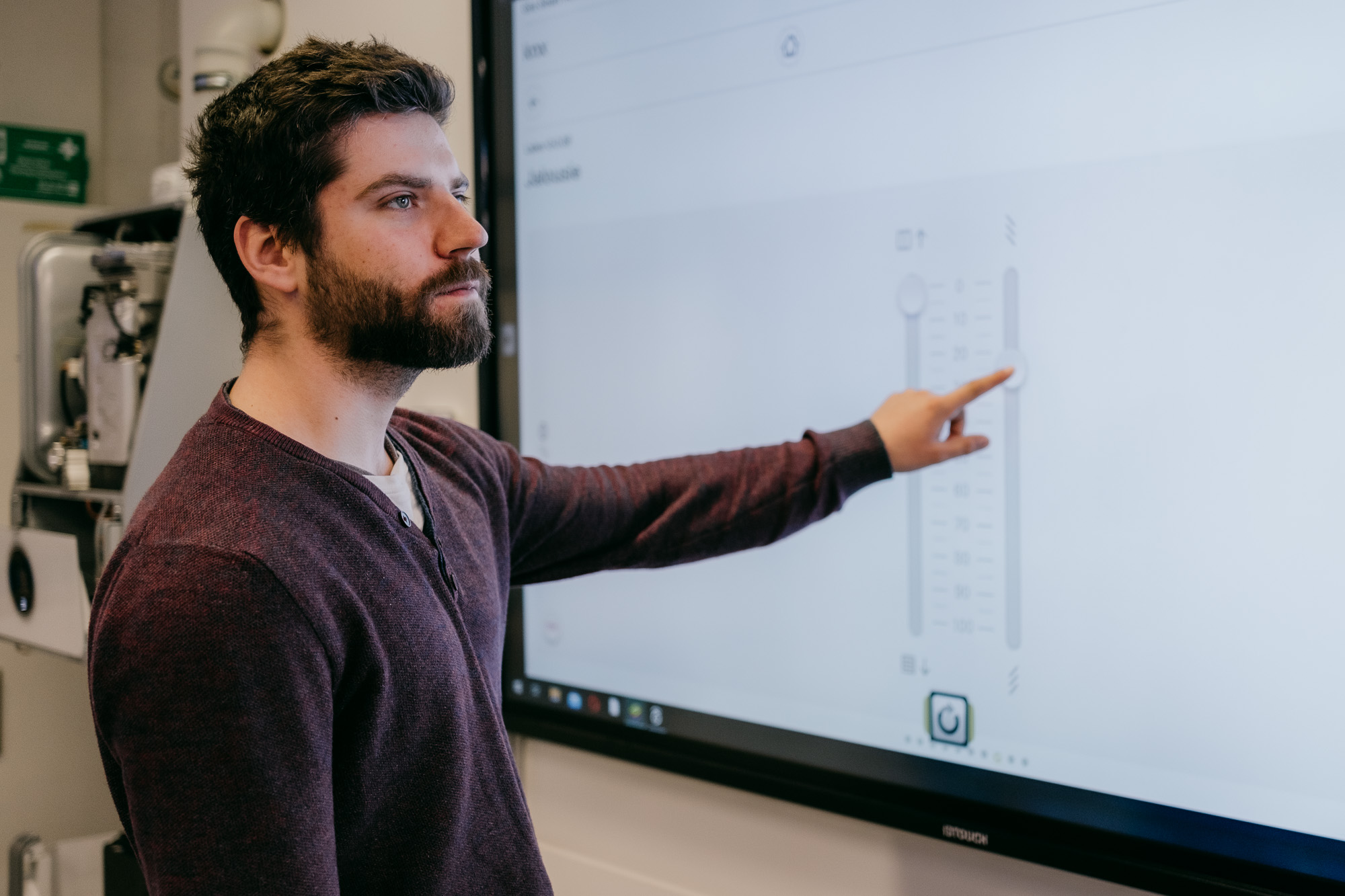 FIT-Master-Studierender testet die Gebäudeautomation, die an einem Bildschirm bedient wird