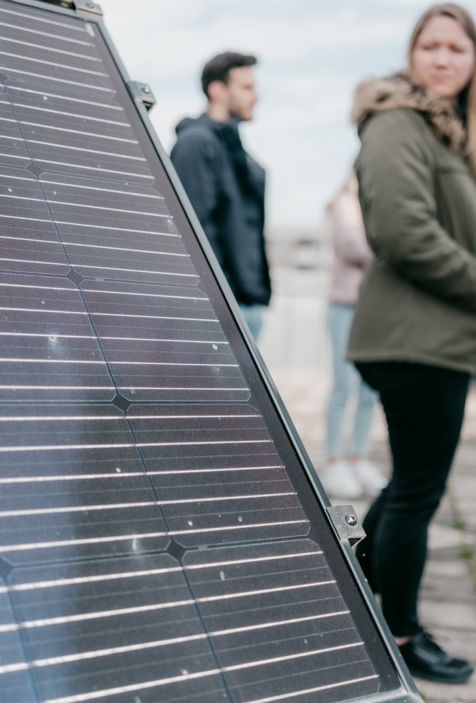 Studierende sehen sich eine Solaranlage auf dem Dach der Hochschule München an