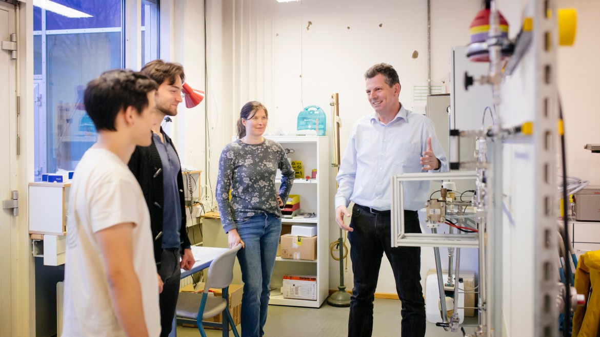 Professor mit Energie- und Gebäudetechnik-Studierenden im Labor 