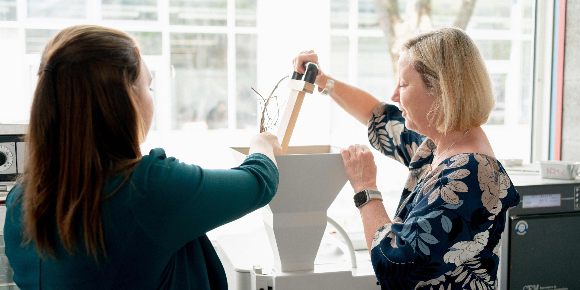 Professorin und Studentin beim Häckseln von Einjahrespflanzen