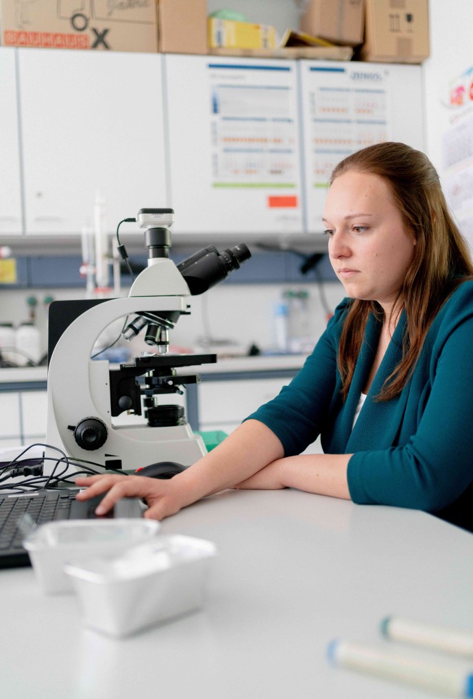 Papier-Studentin am Mikroskop