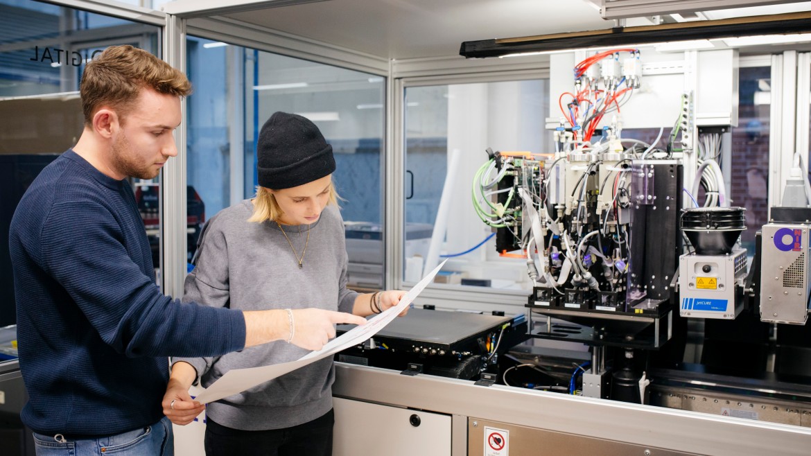 Zwei Studierende vor Druckmaschine 