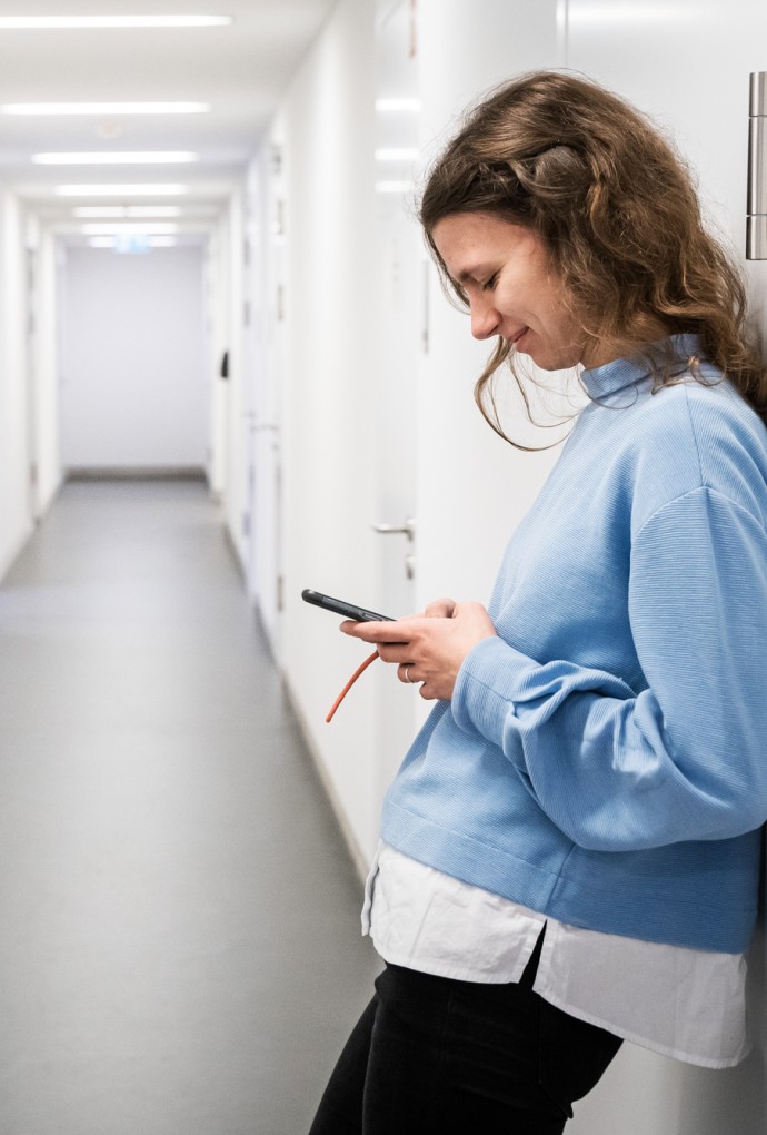 Frau mit Handy im Flur