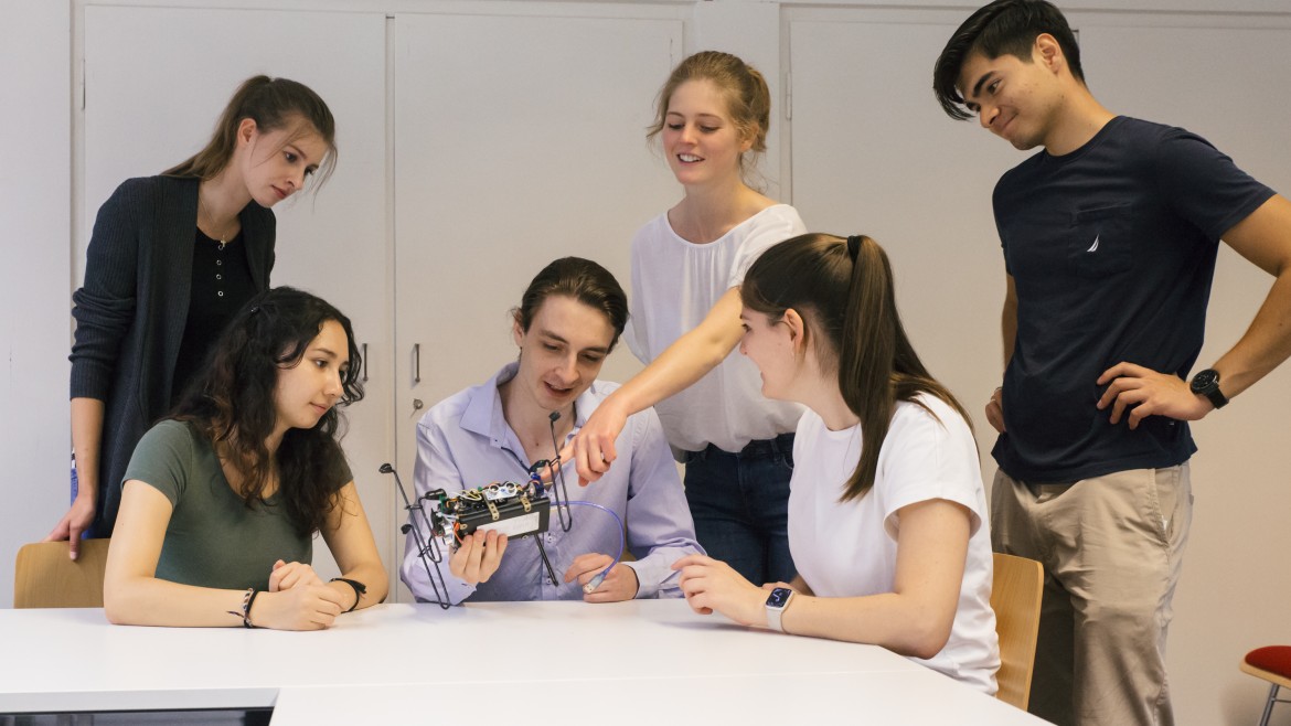 Studierende besprechen die Konstruktion eines mechatronischen Gerätes