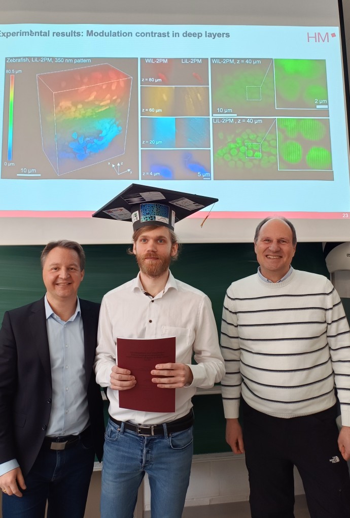 Promotion Patrick Byers, im Bild in der Mitte mit Doktorhut und mit seinen Betreuern
