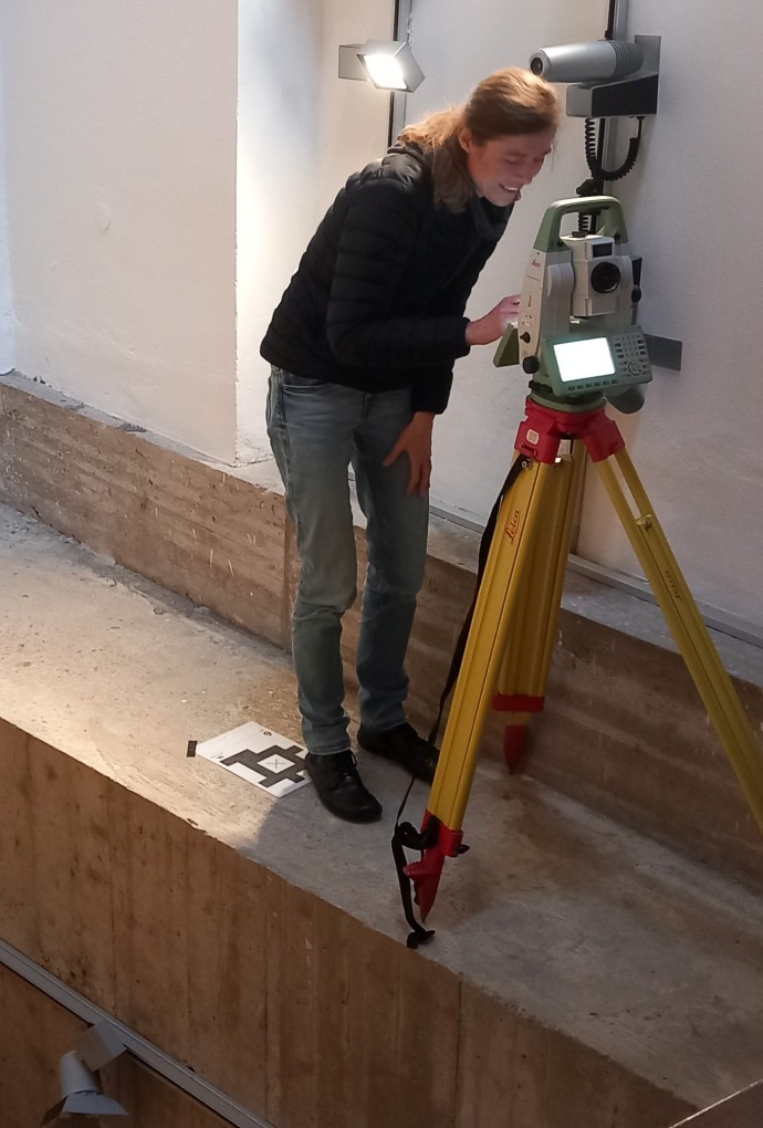 Person mit Stativ an Kante