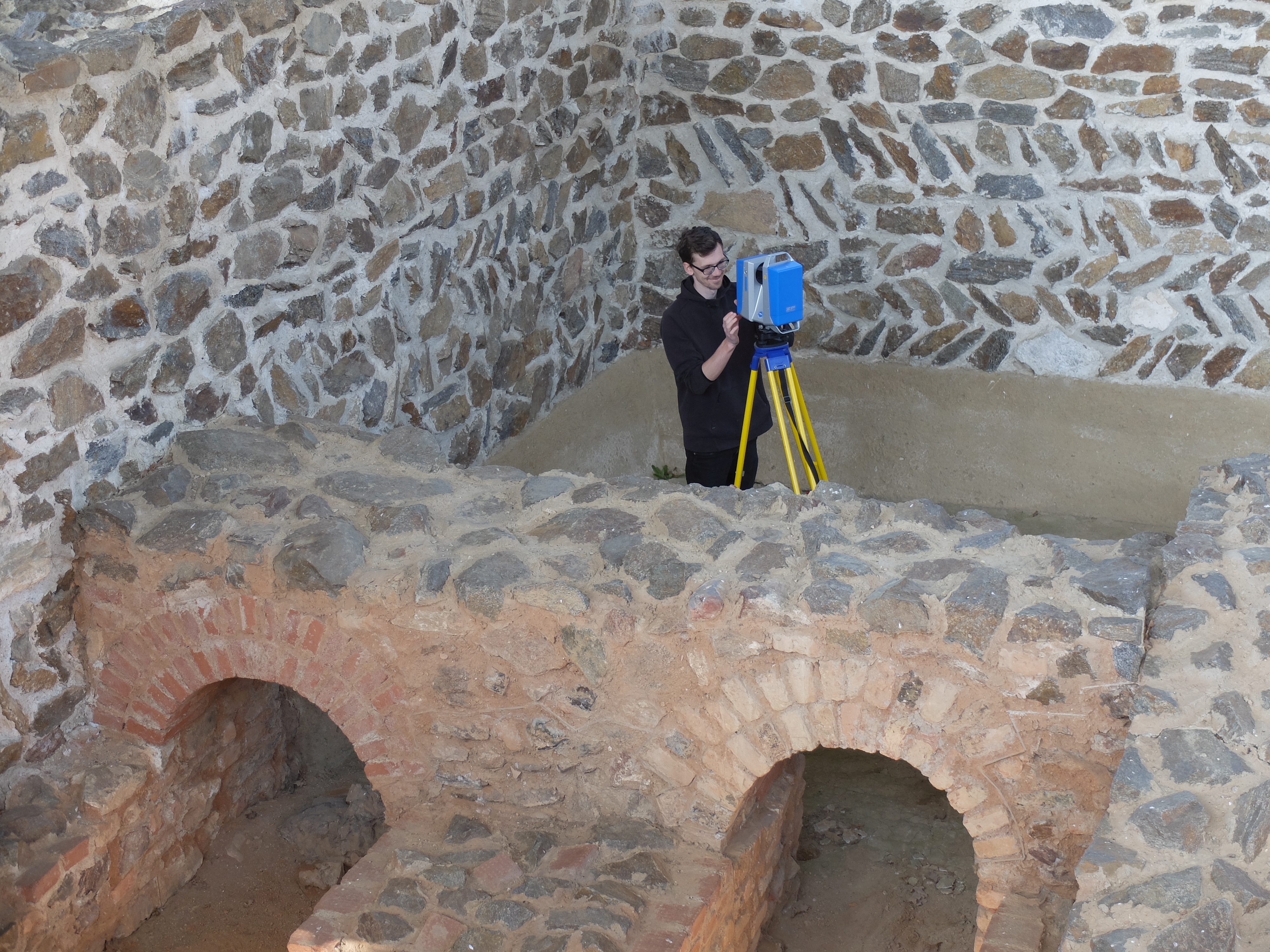 Person mit Scanner zwischen Mauern