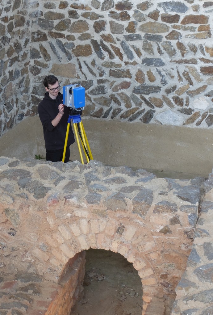 Person mit Scanner zwischen Mauern