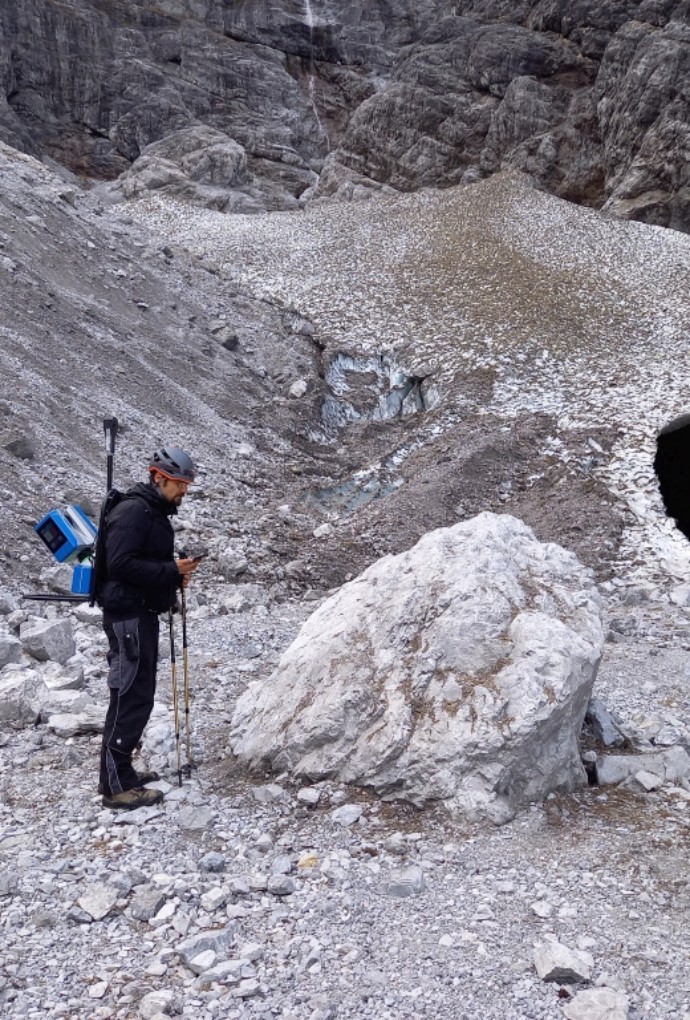 Person mit Instrument vor Gletschertor