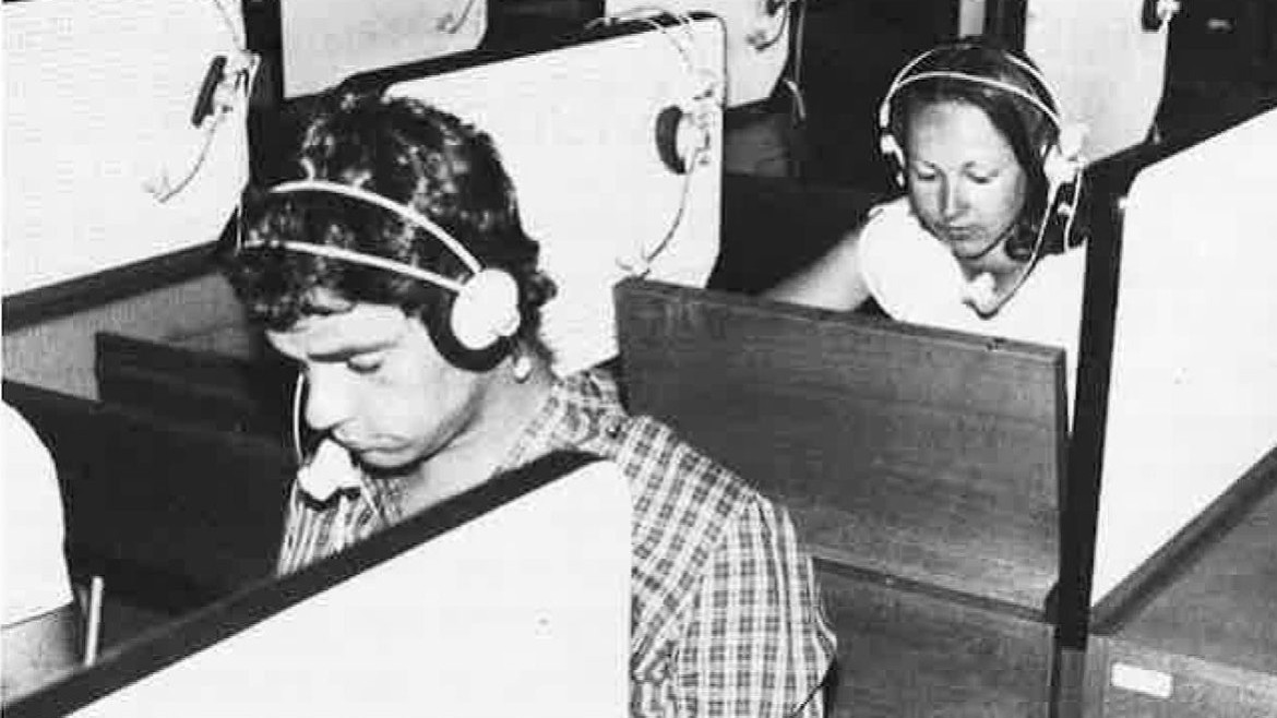 Studierende im Hörsaal mit Sichtschutzblenden und Kopfhörern (1981)