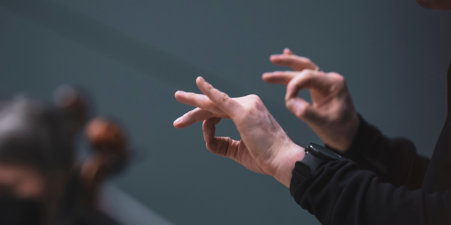 Dirigent leitet das Orchester an, Fokus auf die Hände, kein Gesicht zu sehen
