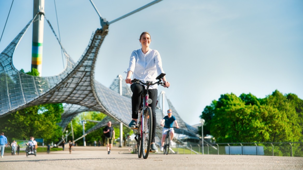 Woman rides a bicycle through the Olympic Park in Munich.