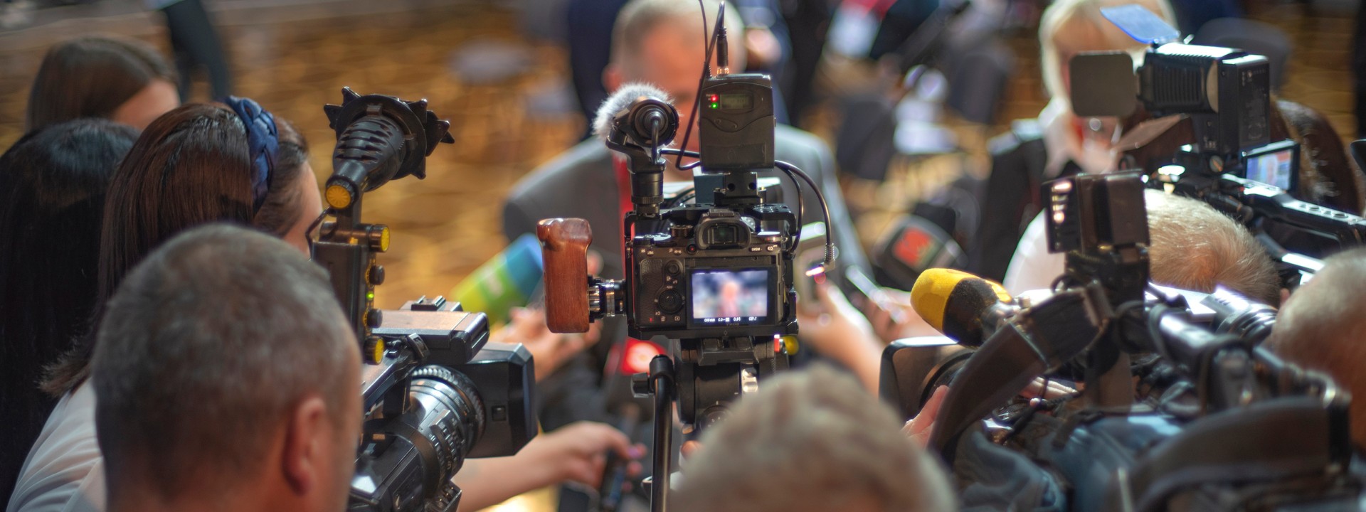 Crowded Press Conference with Video Cameras and Microphones for Breaking News Concept 